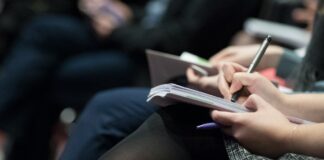 고용보험 재원, 재직자 교육에 집중 투자해야 selective focus photography of people sitting on chairs while writing on notebooks